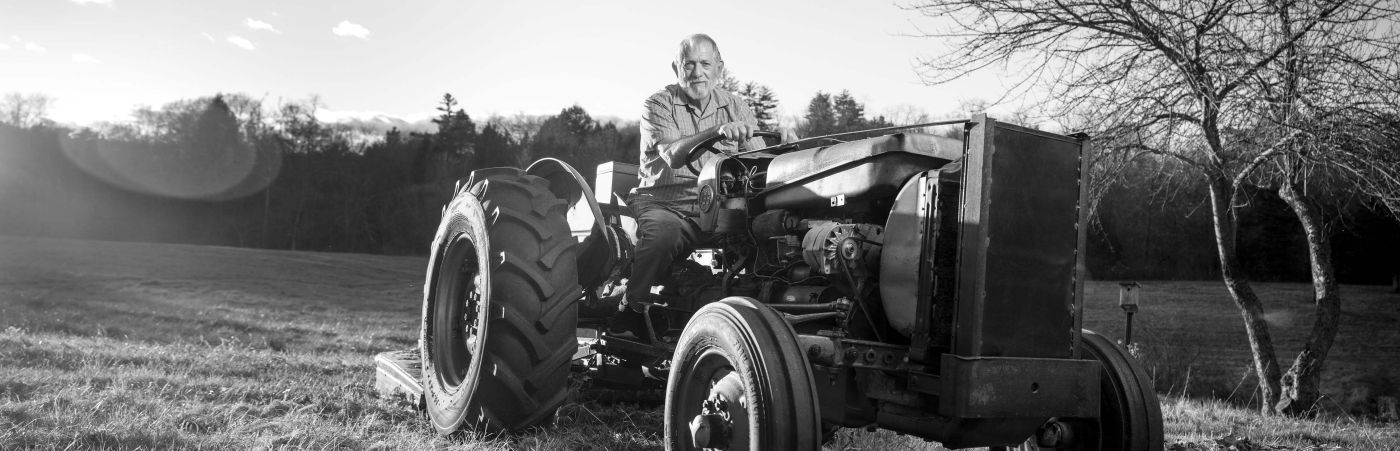 Mark Girard seated on tractor in field.