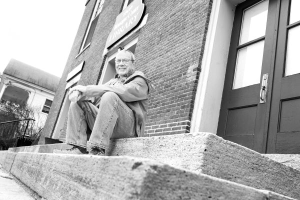 Man seated on stone steps.